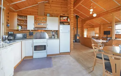 a kitchen with white appliances and a dining room at Holiday Home Vinderup With Fireplace 07 in Vinderup