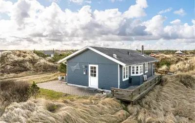 a small blue house in the middle of a field at Holiday Home Frøstrup With Fireplace 10 in Frøstrup