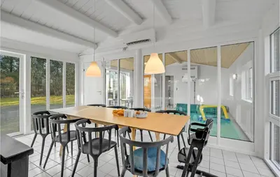 a dining room with a wooden table and chairs at Beautiful Home In Farsø With Kitchen in Farsø