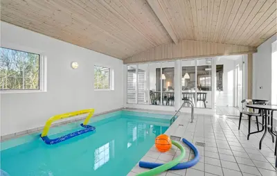 an indoor swimming pool with a pool slide in a house at Beautiful Home In Farsø With Kitchen in Farsø