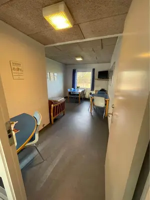 a room with a waiting room with a table and chairs at Roslev Vandrerhjem-Hostel in Roslev