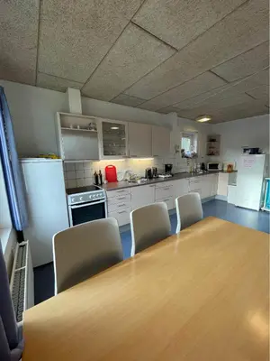 a kitchen with a table and chairs and a refrigerator at Roslev Vandrerhjem-Hostel in Roslev