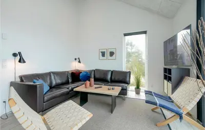 a living room with a leather couch and a table at Holiday Home Blokhus With Hot Tub Iv in Blokhus