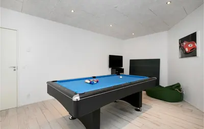 a room with a pool table in a room with a wall at Holiday Home Blokhus With Hot Tub Iv in Blokhus