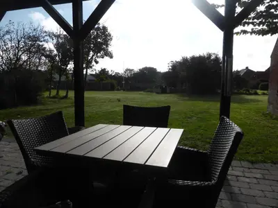 a wooden table and chairs in a yard at Harboøre Hotel in Harboør