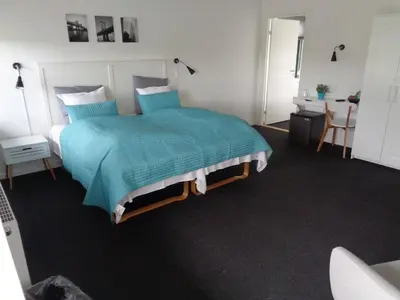 a bedroom with a bed with a blue comforter at Hotel St. Binderup in Store Binderup