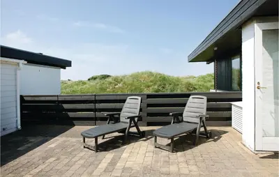 a group of chairs sitting on a patio at Holiday Home Pandrup With Fireplace Ii in Pandrup