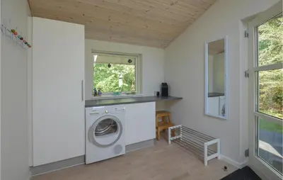 a laundry room with a washing machine and a window at Holiday Home Hurup Thy With Hot Tub I in Sønder Ydby