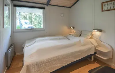 a bedroom with a bed and a window at Holiday Home Hurup Thy With Hot Tub I in Sønder Ydby