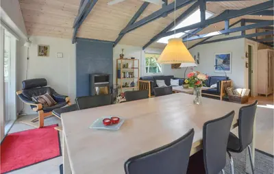 a dining room and living room with a table and chairs at Holiday Home Hurup Thy With Hot Tub I in Sønder Ydby