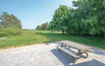 a wooden picnic bench sitting on a brick patio at Holiday Home Veslos With Fireplace I in Højstrup