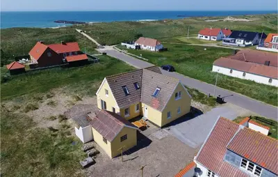 an aerial view of a house and the ocean at Klitrosen in Harboør