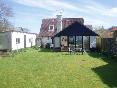 a house with a large yard with chairs in it at Strandhuset Holiday Home in Glyngøre
