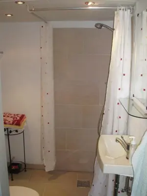 a bathroom with a shower curtain and a sink at Strandhuset Holiday Home in Glyngøre