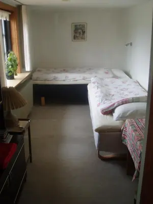a bedroom with two twin beds and a window at Strandhuset Holiday Home in Glyngøre