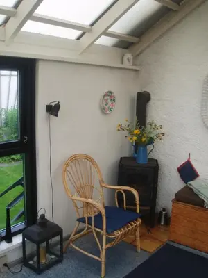 a room with a rocking chair and a window at Strandhuset Holiday Home in Glyngøre