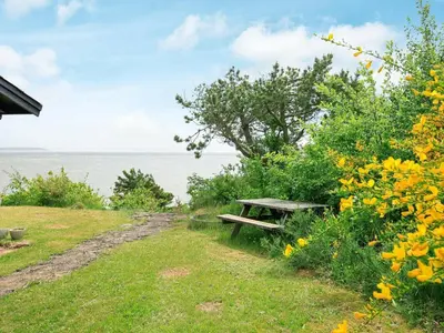 a picnic table on a hill next to the water at Secluded Beach Retreat - By Traum Ferienwohnungen in Lihme