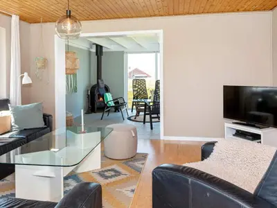 a living room with a couch and a glass table at 8 person holiday home in Frøstrup-By Traum in Lild Strand