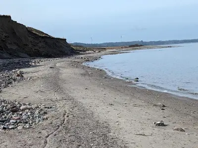 a beach with rocks and water on a sunny day at 8 person holiday home in Løgstør-By Traum in Trend