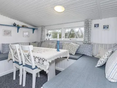 a room with a table and chairs and a couch at 8 person holiday home in Løgstør-By Traum in Trend