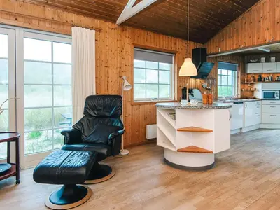 a kitchen with a black leather chair and a counter at 12 person holiday home in Harboøre-By Traum in Vrist