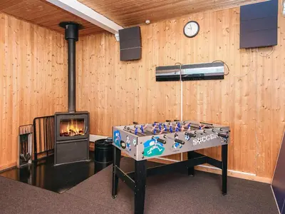 a room with a fireplace and a table and a stove at 12 person holiday home in Harboøre-By Traum in Vrist