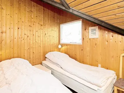 two beds in a room with wood paneling at 6 person holiday home in Saltum-By Traum in Saltum