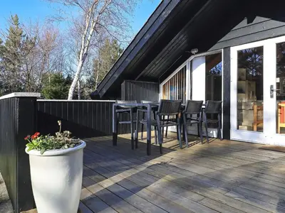 a wooden deck with a table and chairs on it at 6 person holiday home in Saltum-By Traum in Saltum
