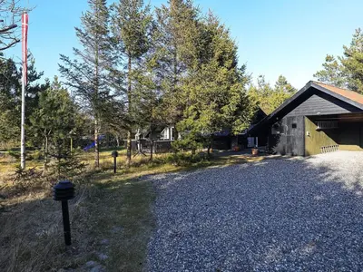a house with a gravel driveway next to a building at 6 person holiday home in Saltum-By Traum in Saltum