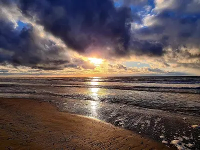 a sunset on a beach with the ocean at Bright Beach House Retreat - By Traum Ferienwohnungen in Trudslev