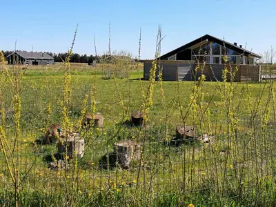 a fence in a field with a house in the background at Bright Beach House Retreat - By Traum Ferienwohnungen in Trudslev
