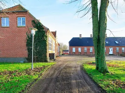 a dirt road in front of a brick building at 26 person holiday home in Roslev-By Traum in Åsted