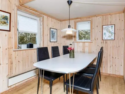 a dining room with a white table and black chairs at 6 person holiday home in Vestervig-By Traum in Vestervig