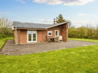 a brick house with a patio and a table at 7 person holiday home in Struer-By Traum in Humlum