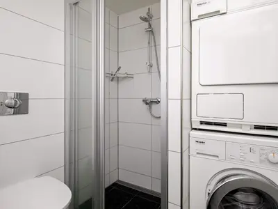 a bathroom with a washing machine and a shower at Luxury Seaside Retreat - By Traum Ferienwohnungen in Tranum Strand