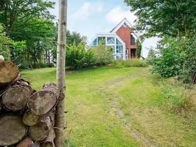 a house on a hill with a dirt road in front at Luxury Retreat with Pool - By Traum Ferienwohnungen in Hvalpsund