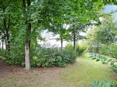a group of trees and bushes in a park at Luxury Retreat with Pool - By Traum Ferienwohnungen in Hvalpsund