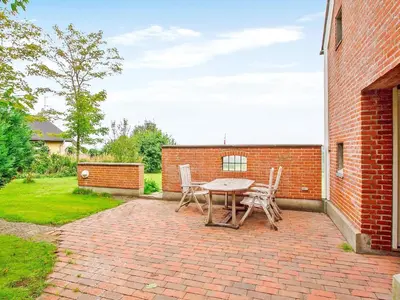 a brick patio with a table and chairs at Luxury Retreat with Pool - By Traum Ferienwohnungen in Hvalpsund
