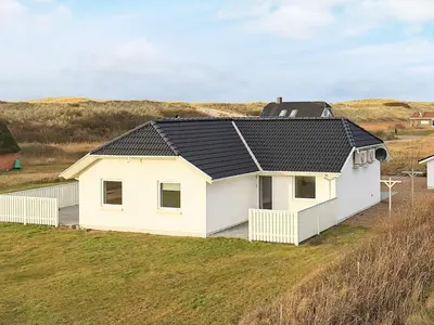 a white house with a black roof on a field at Luxury Spa Retreat by Sea in Vrist