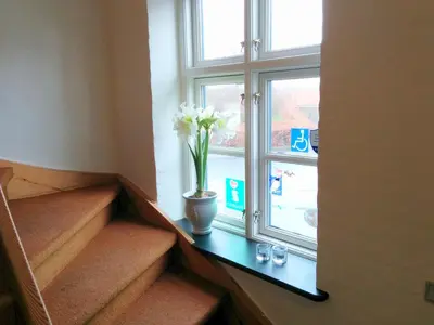 a vase with flowers sitting on a table next to a window at Sevel Kro in Vinderup