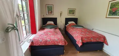 two twin beds in a room with a window at Næsbydale Badehotel in Ranum