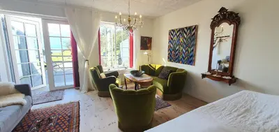 a living room with a bed and chairs and a table at Næsbydale Badehotel in Ranum