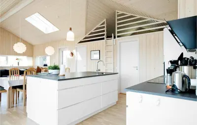 a kitchen with white cabinets and a black counter top at Studio Holiday Home In Lokken in Løkken