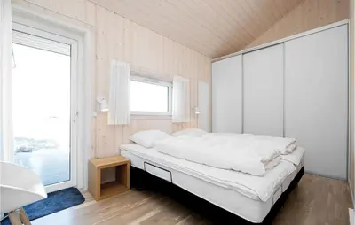 a bedroom with a large bed and a large window at Studio Holiday Home In Lokken in Løkken