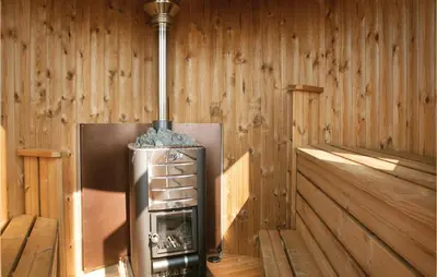 a wood paneled room with a stove in a room at Studio Holiday Home In Lokken in Løkken
