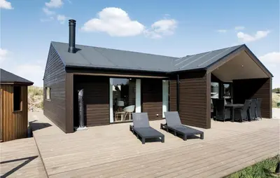 a wooden deck with two chairs and a house at Studio Holiday Home In Lokken in Løkken