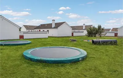 three trays in the grass in front of houses at Two-Bedroom Holiday Home In Pandrup in Pandrup