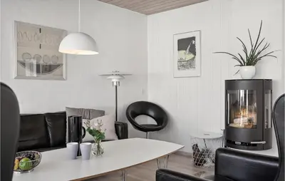 a living room with a table and black chairs at Two-Bedroom Holiday Home In Pandrup in Pandrup