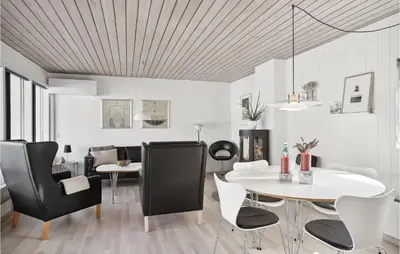a dining room with black chairs and a white table at Two-Bedroom Holiday Home In Pandrup in Pandrup