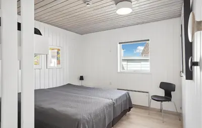 a bedroom with a bed and a chair in it at Two-Bedroom Holiday Home In Pandrup in Pandrup